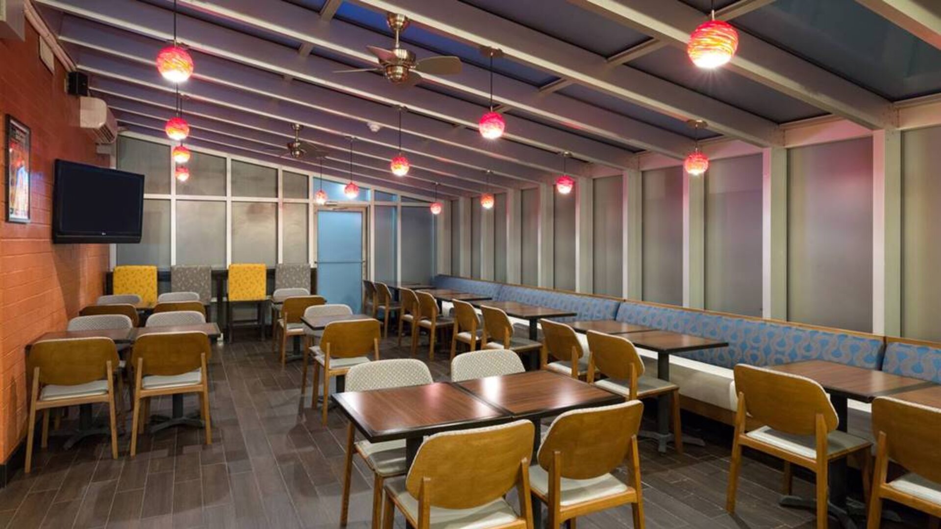 The hotel’s breakfast area, with hard floor and tables for two or four diners.