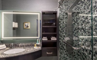 Spacious guest bathroom with shower at Hotel Clique Calgary Airport.