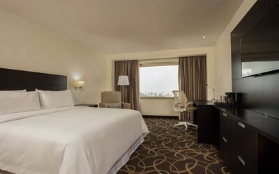 Delux king bed with TV and business desk at Doubletree By Hilton Toluca.