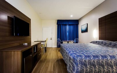 Day use room with dining table, work desk and TV at Palace Inn Blue Gessner.