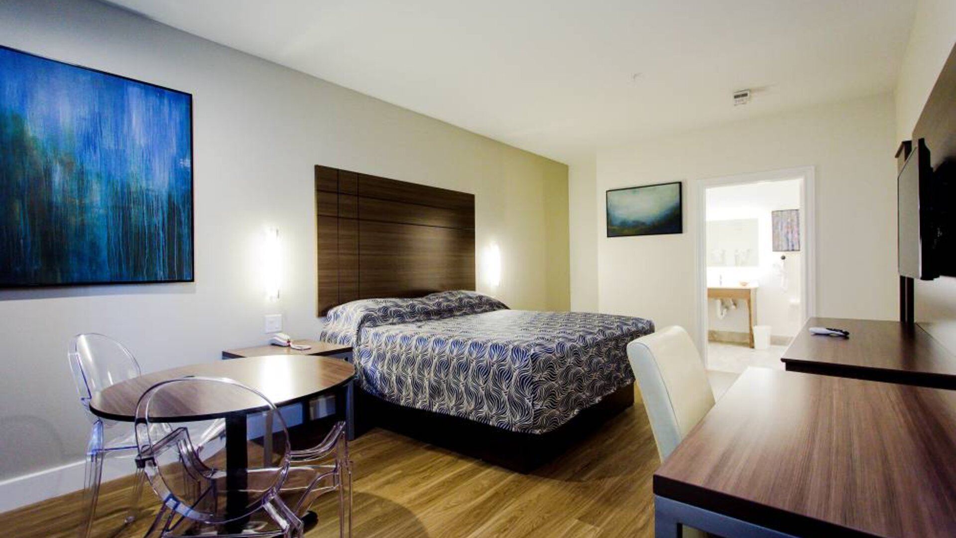 Day use room with dining table, work desk and TV at Palace Inn Blue Gessner.