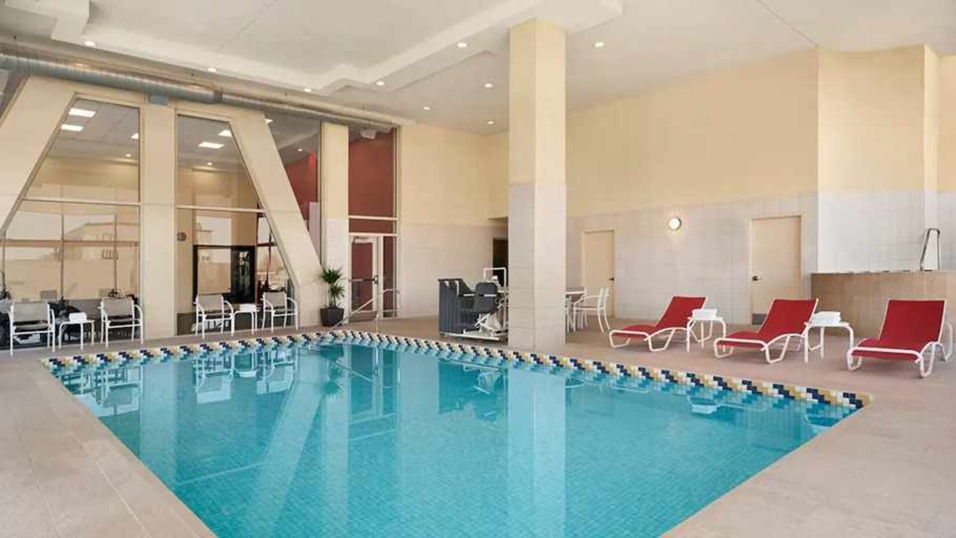 Lovely indoor pool with surrounding seating area and sun beds at Homewood Suites by Hilton University City.