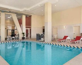 Lovely indoor pool with surrounding seating area and sun beds at Homewood Suites by Hilton University City.