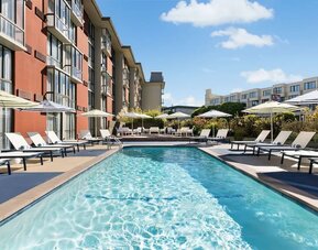 Stunning outdoor pool with sun beds and umbrellas at Hotel Caza.