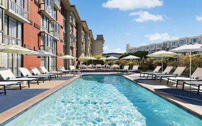 Stunning outdoor pool with sun beds and umbrellas at Hotel Caza.