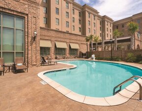 Outdoor pool with pool chairs at Embassy Suites By Hilton Savannah.