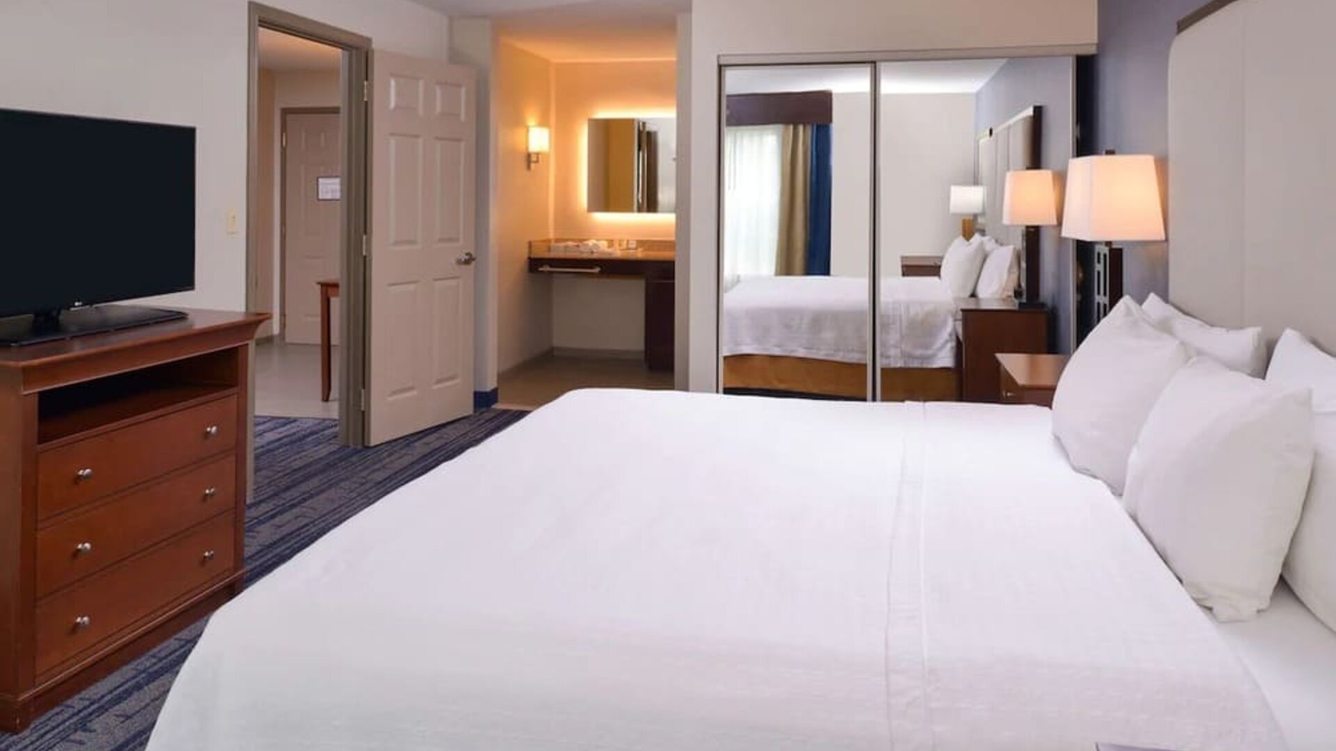 Delux king bed with TV at Homewood Suites By Hilton Dallas-Lewisville.