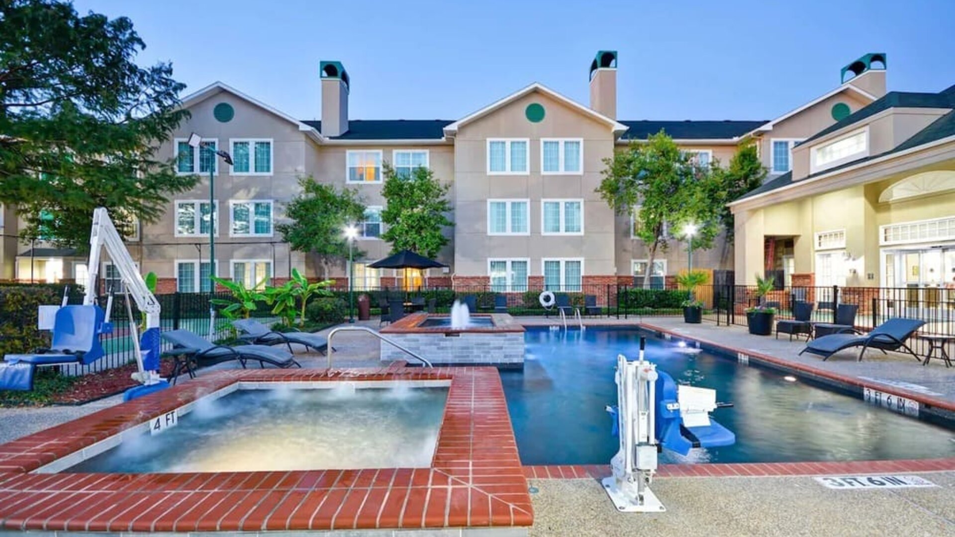Luxurious pool area with jacuzzi hot tub at Homewood Suites By Hilton Dallas-Lewisville.