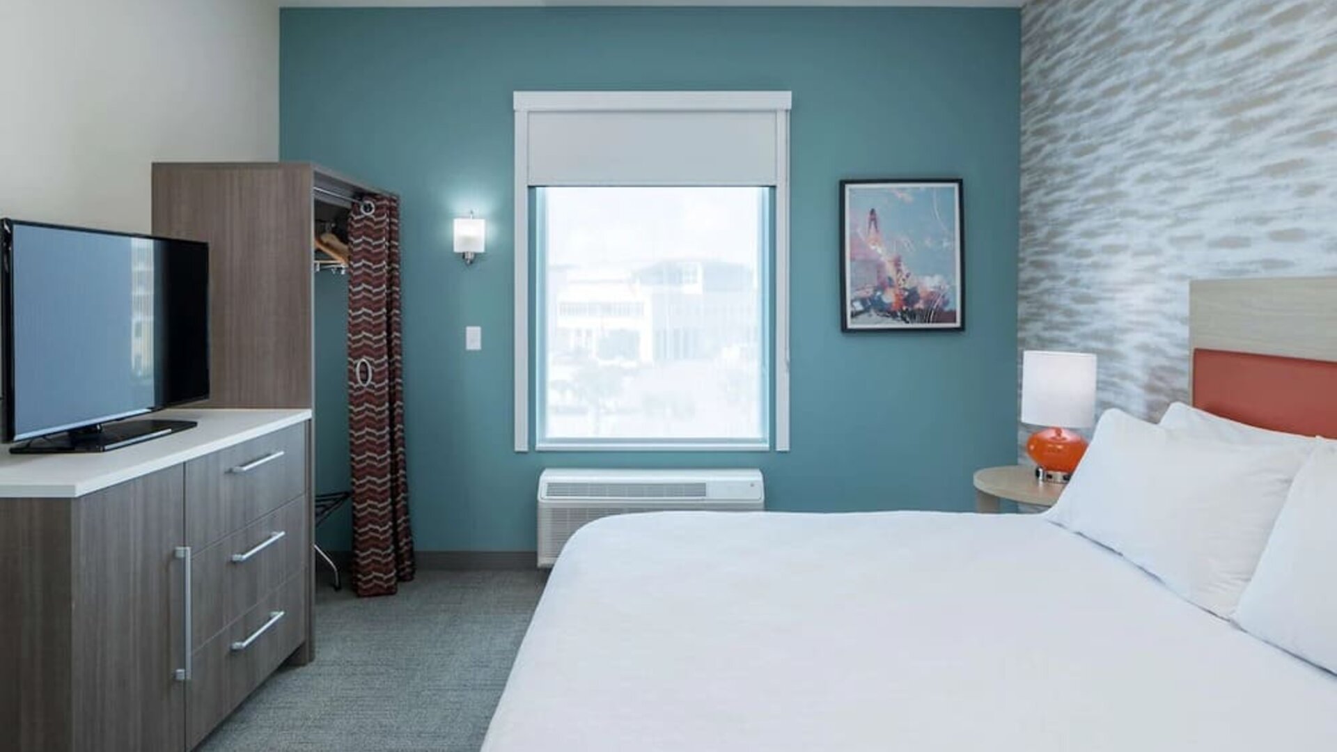 King bed with TV at Home2 Suites By Hilton Cape Canaveral Cruise Port.