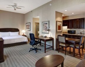 Spacious king bed with business desk at Homewood Suites By Hilton Burlington.