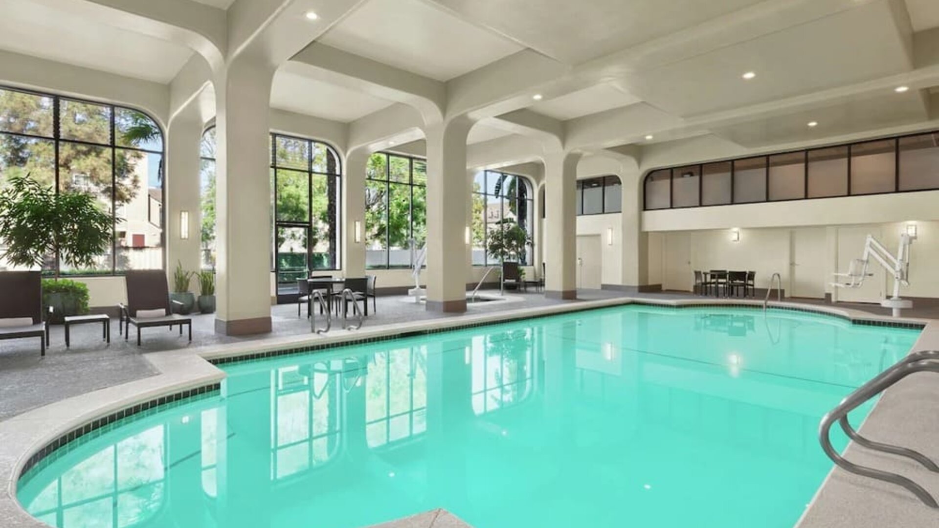 Lovely indoor pool with seating area at Embassy Suites By Hilton Arcadia Pasadena Area.