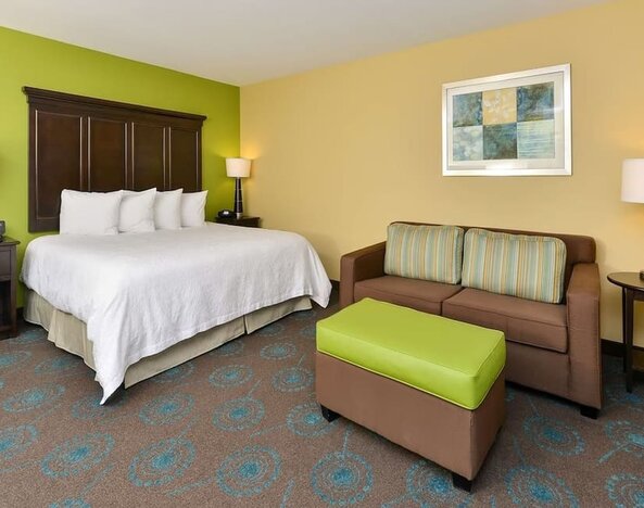 King bed with lounge area at Hampton Inn Iowa City/University Area.
