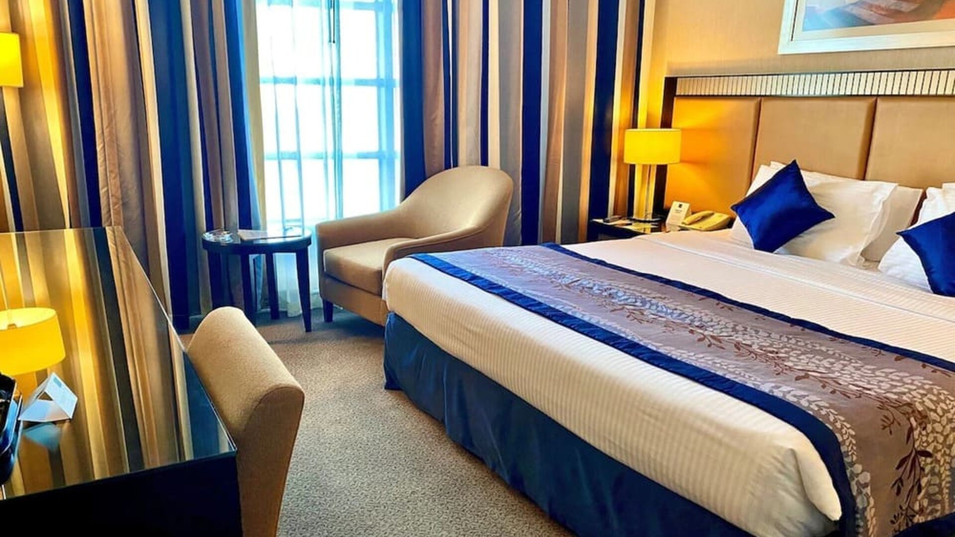 King bed with natural light at Millennium Central Doha.