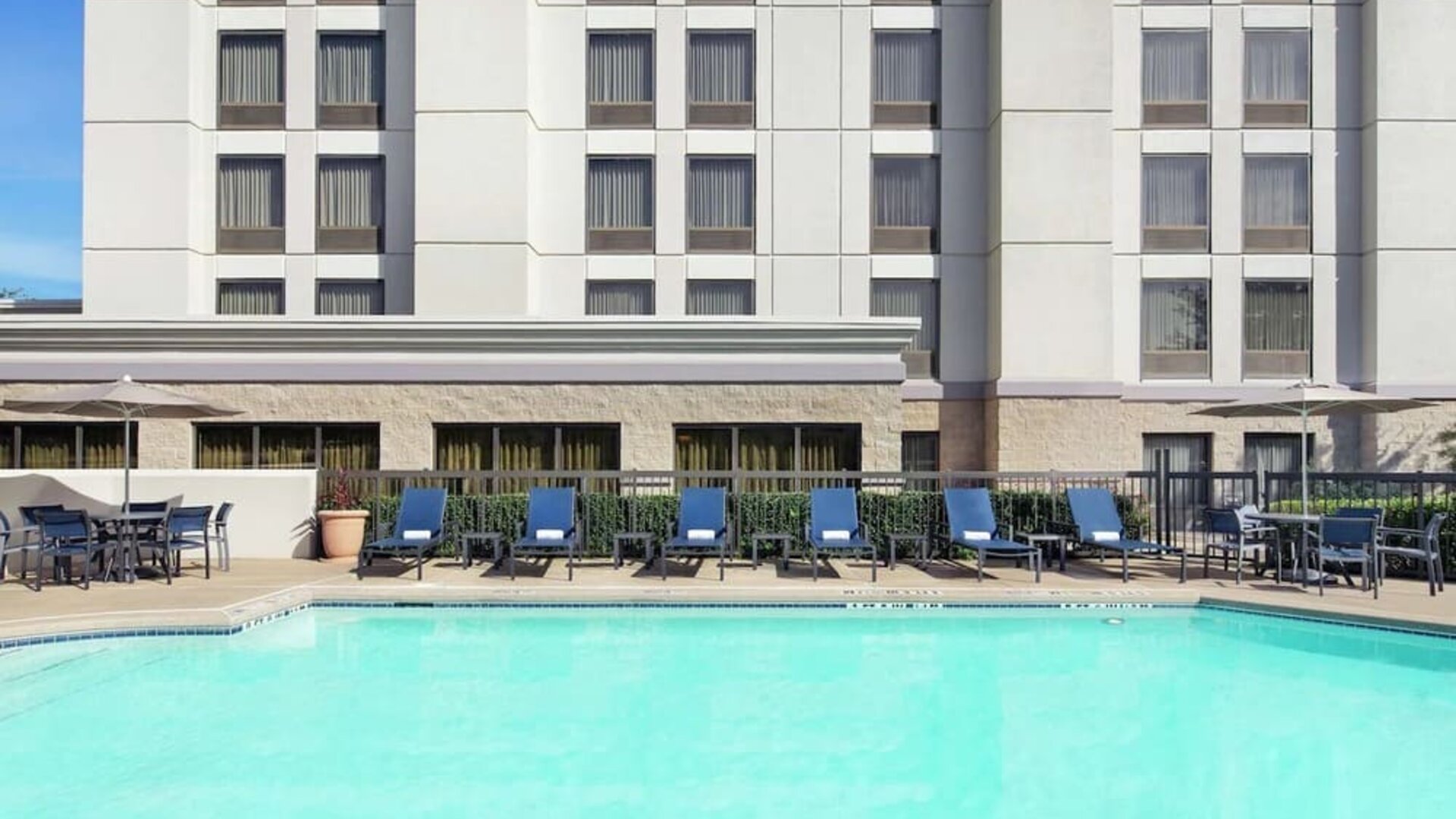 Relaxing pool area with pool chairs at Hampton Inn Dallas-Irving-Las Colinas.