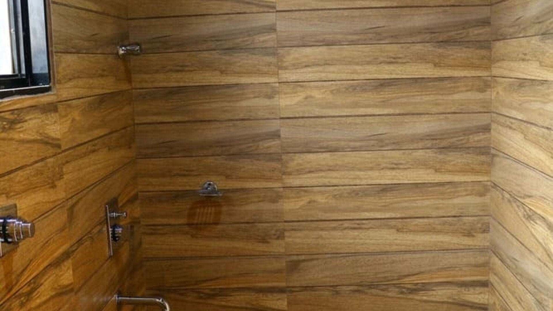 Guest bathroom with shower and towels at Hotel Alka Residency.