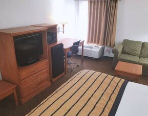 Sofa, work desk and TV inside day use room of the Coratel Inn & Suites By Jasper New Braunfels IH-35 EXT 189.