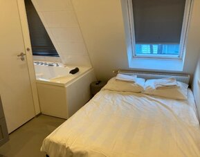 Cozy guest room with a double bed, whirlpool bathtub, skylight window, and fresh linens at Hotel Chao 24/7.