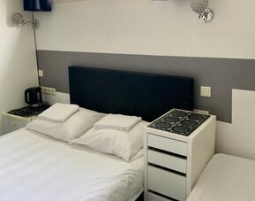 Guest room with a double bed, bedside tables, natural light, and modern furnishings at Hotel Chao 24/7.