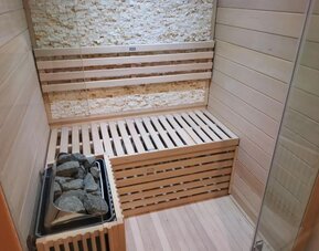 Private in-room sauna with wooden seating, stone heater, and relaxing wellness amenities at Hotel Chao 24/7.