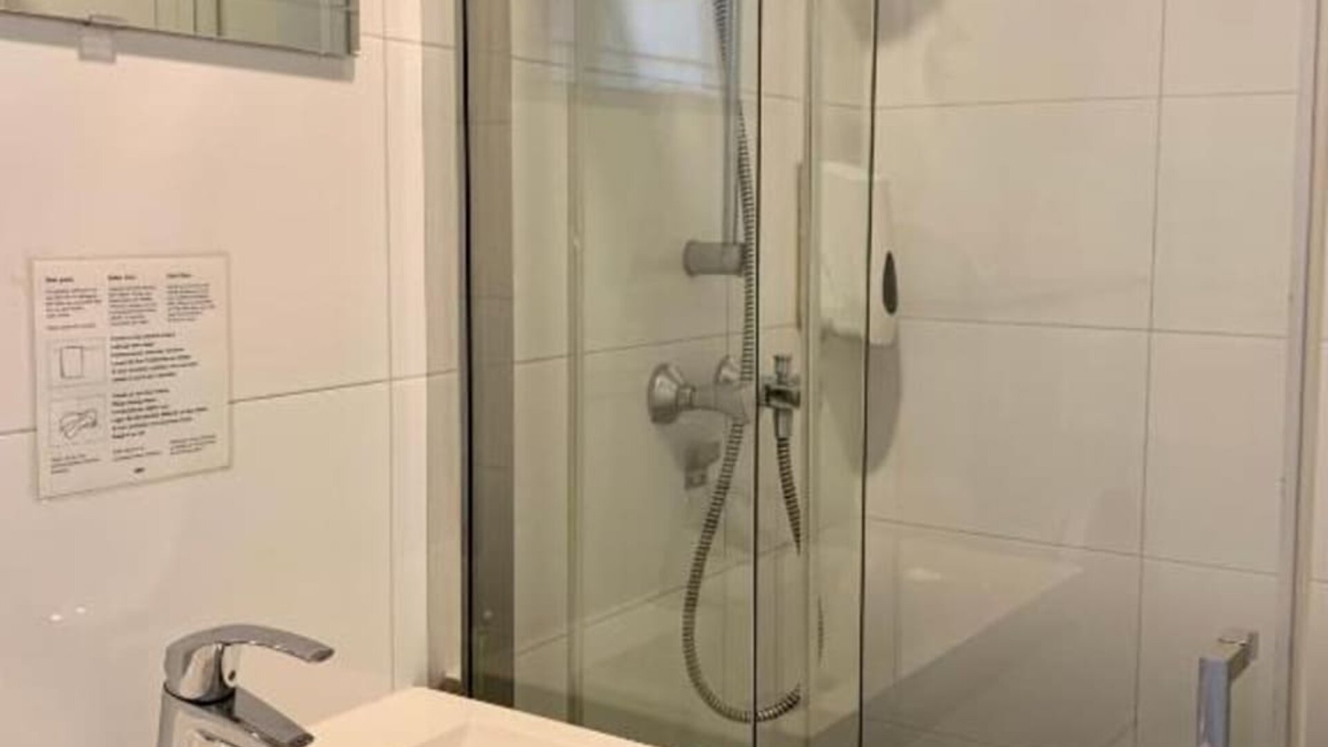 Modern bathroom featuring a glass-enclosed shower, vanity sink, and contemporary fixtures at Hotel Chao 24/7.