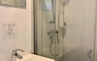 Modern bathroom featuring a glass-enclosed shower, vanity sink, and contemporary fixtures at Hotel Chao 24/7.