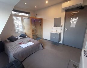 Wellness suite featuring a private sauna, sleeping area, and contemporary interior design at Hotel Chao 24/7.