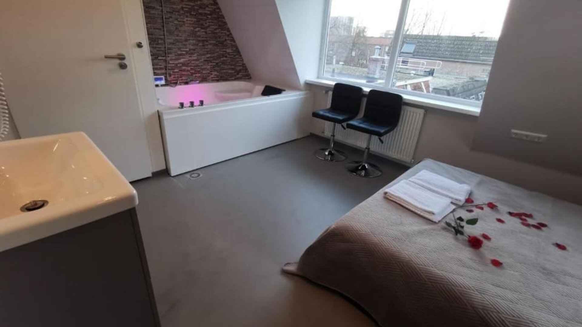 Spacious suite with whirlpool bathtub, seating area, large windows, and comfortable accommodations at Hotel Chao 24/7.