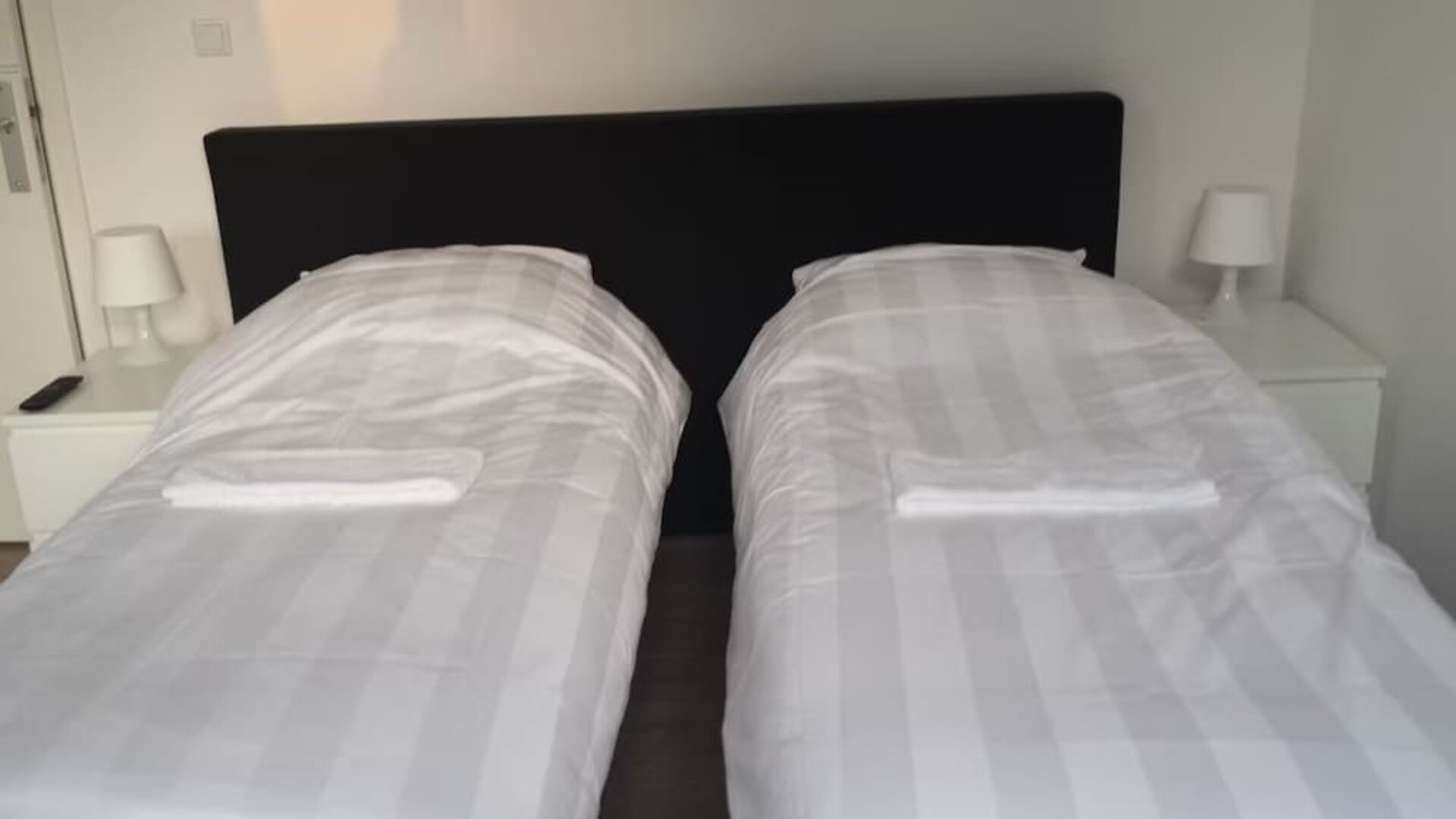 Twin guest room with two single beds, bedside tables, and crisp white linens at Hotel Chao 24/7.