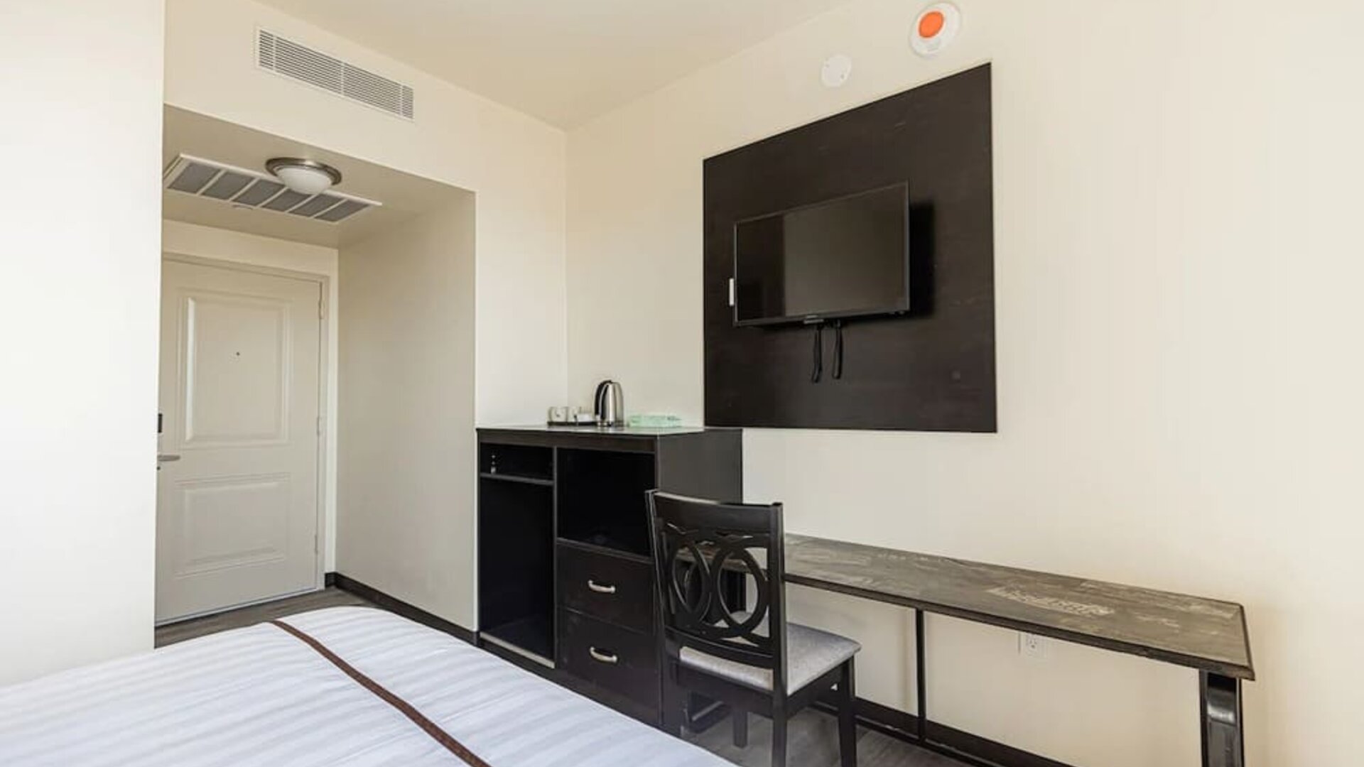 Day room with work space ideal for remote work at Astoria Inn LaGuardia Hotel.