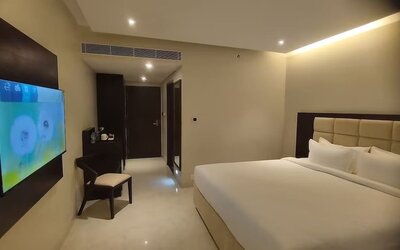 King bed with TV at Mayur Belgaum Presidency Hotel & Spa.