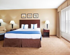 delux king room with couch at Holiday Inn Aurora North- Naperville.