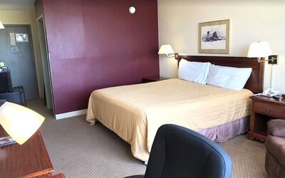 Day use room with king bed and work desk at Norwood Inn And Suites Worthington.
