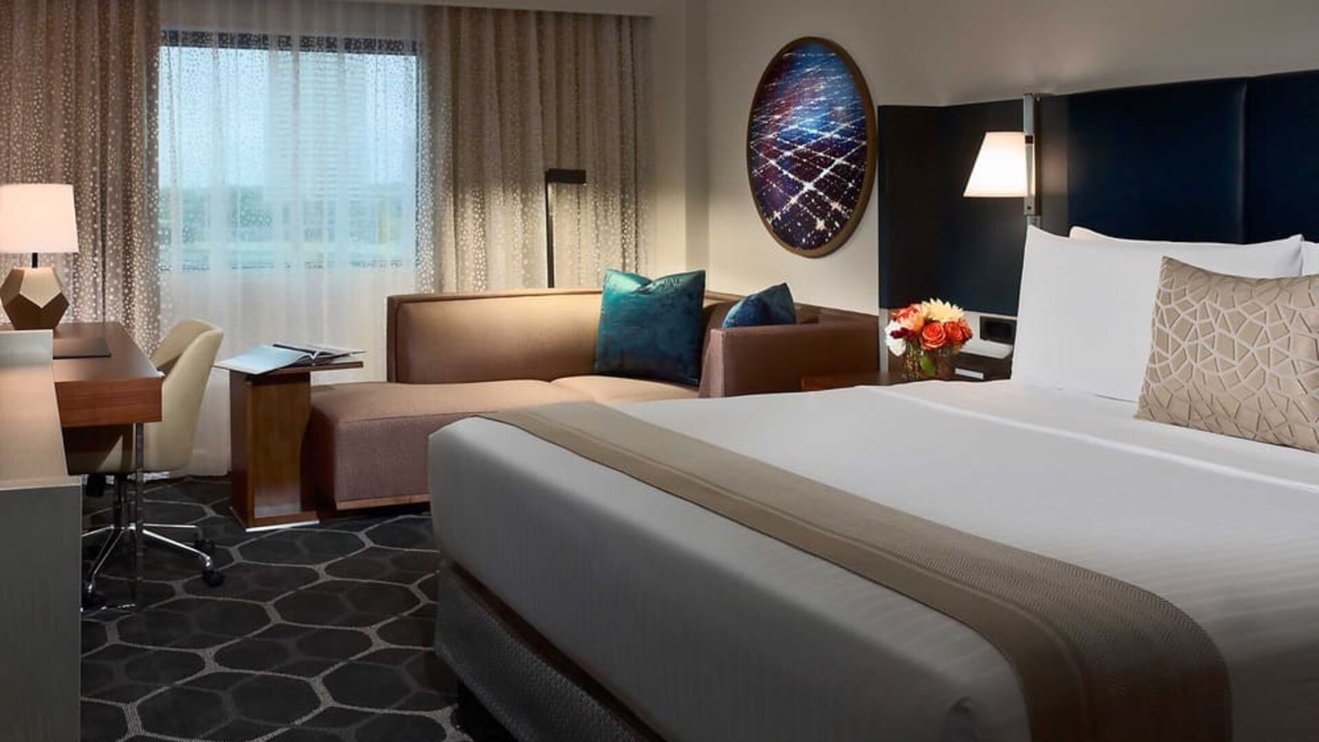 Royal Sonesta Houston Galleria double bed day room, featuring corner sofa and workspace desk and chair.