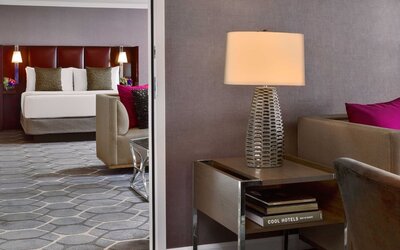 Deluxe king Royal Sonesta Houston Galleria guest room, furnished with coffee table, sofa, and chair.