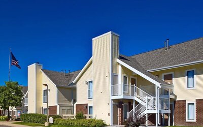 Sonesta ES Suites Tucson’s parking area affords easy access to the hotel, which features a fluttering US flag, and plenty of pleasant greenery.