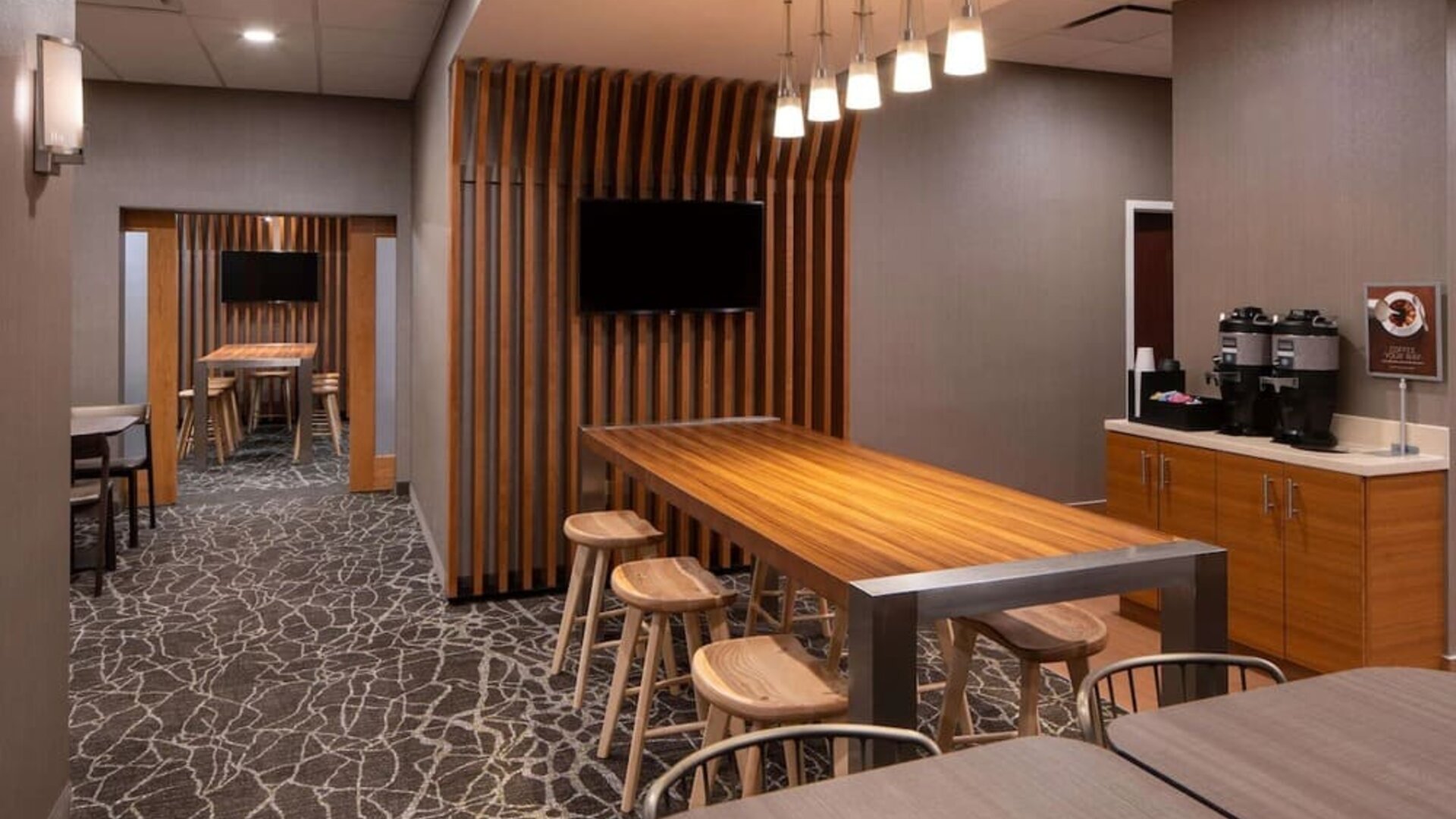 Sonesta Select Nashville Airport Suites meeting room, with long wooden table and a wall-mounted television.