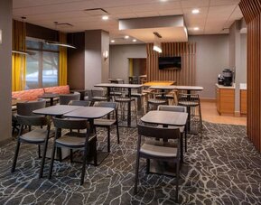 Hotel workspace, including extensive seating and tables for between two and six individuals, and coffee-making facilities.