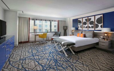 Double bed guest room in Royal Sonesta Washington DC Dupont Circle, including window, chair, and widescreen TV.