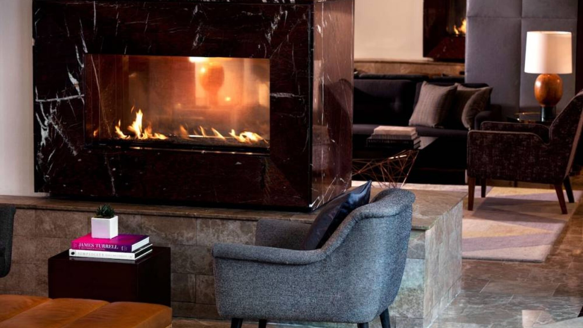 Royal Sonesta Washington DC Dupont Circle’s lobby lounge is furnished with comfortable seating, coffee tables, and a fireplace.