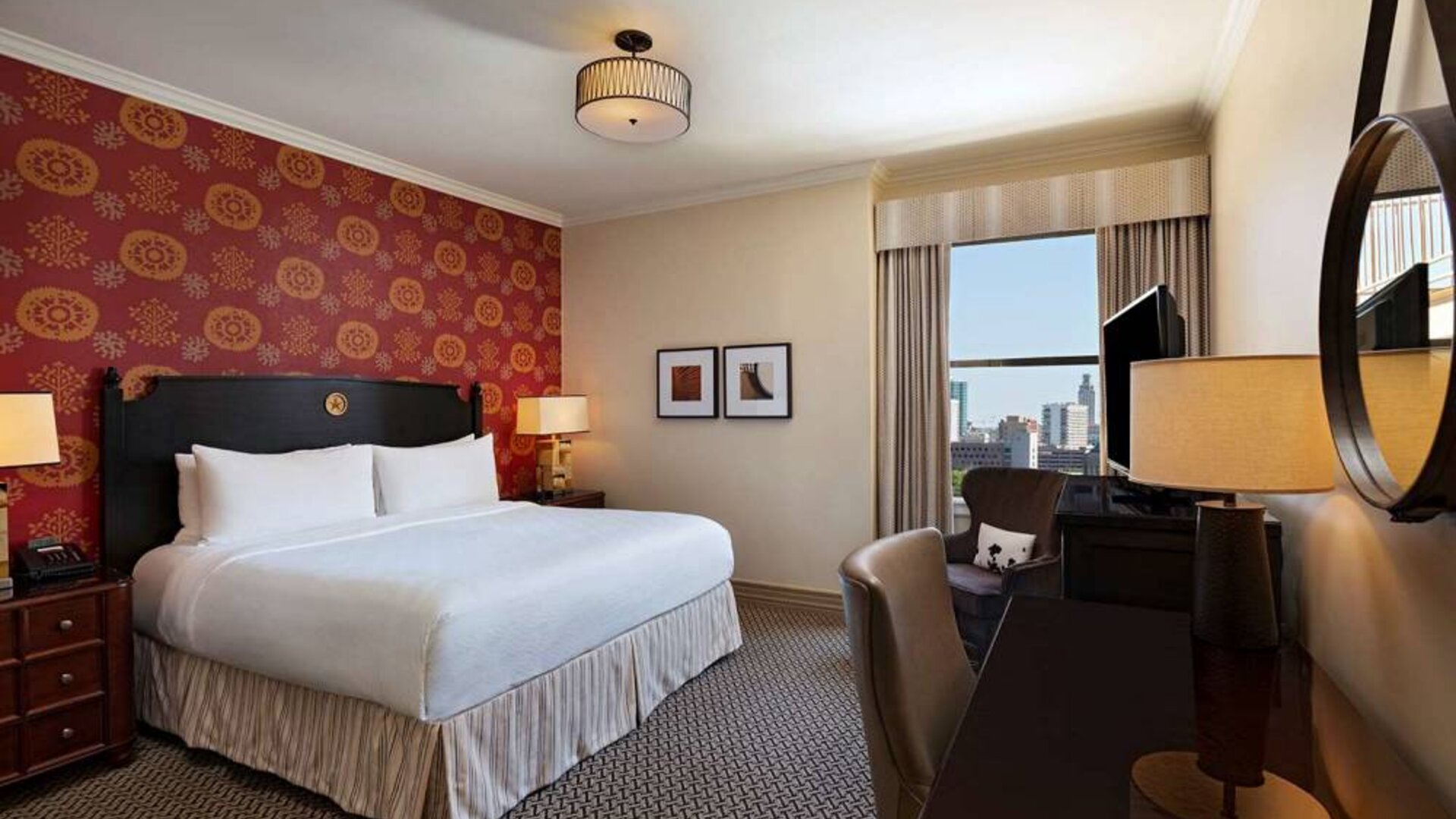 The Stephen F Austin Royal Sonesta Hotel double bed guest room, including window and workspace desk and chair.