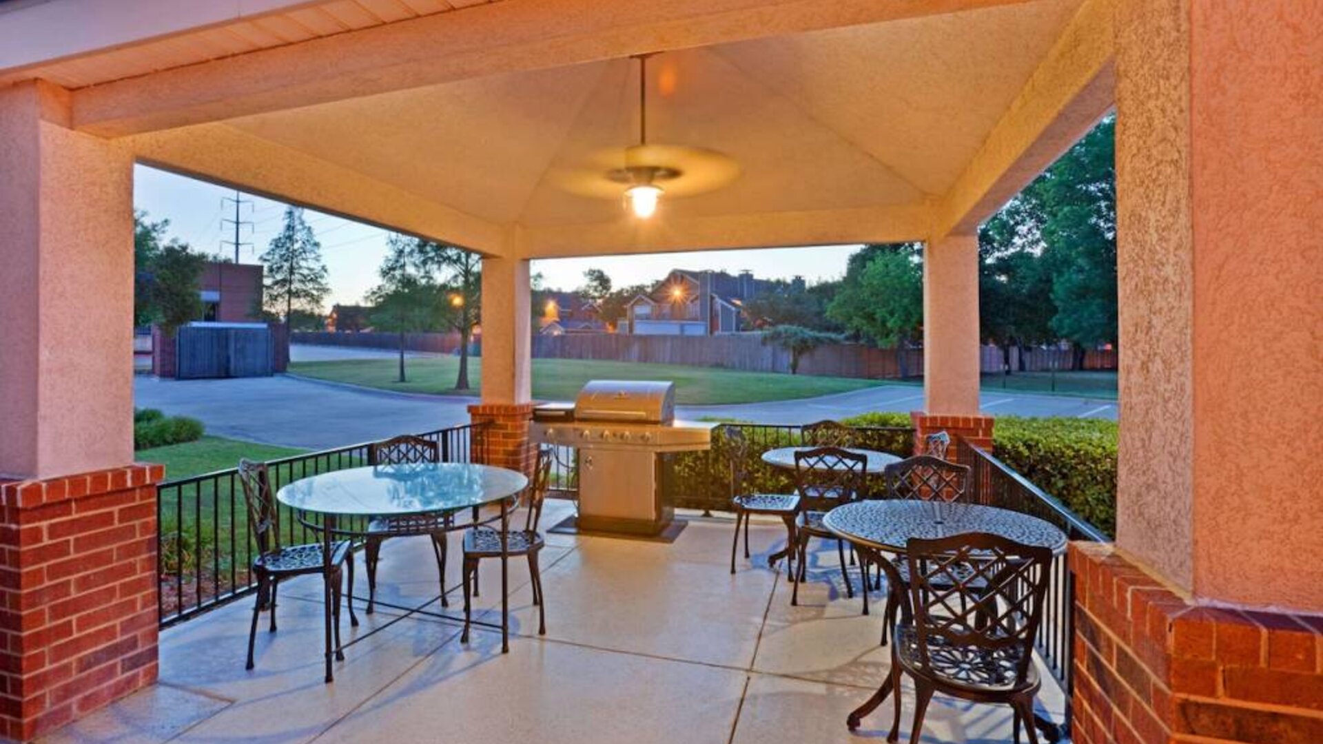 The hotel’s gazebo provides outdoor tables and chairs under cover, with greenery nearby and a barbecue.