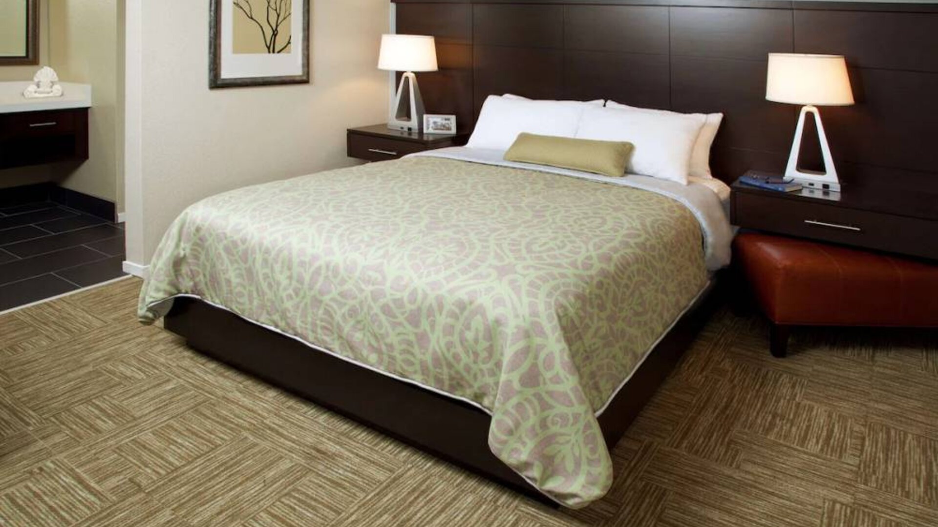 Sonesta ES Suites San Jose Airport double bed guest room, including bedside lamps and an ensuite bathroom.
