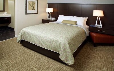 Sonesta ES Suites San Jose Airport double bed guest room, including bedside lamps and an ensuite bathroom.