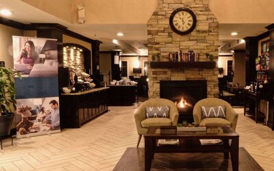 The hotel’s lobby has comfortable seating, a coffee table, reading material, and a cozy fireplace.