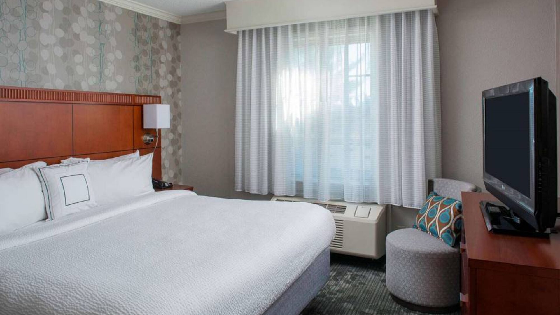 Double bed guest room in Sonesta Select Boston Lowell Chelmsford, including window and television.