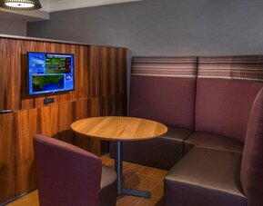 A media pod, featuring coffee table, TV, and comfortable seating where guests can relax and co-work.