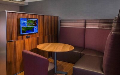 A media pod, featuring coffee table, TV, and comfortable seating where guests can relax and co-work.