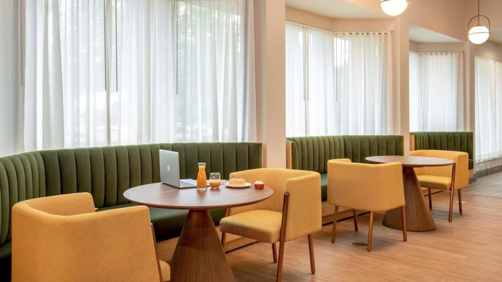 The hotel’s breakfast area has comfy seating, stylish tables, and large windows.