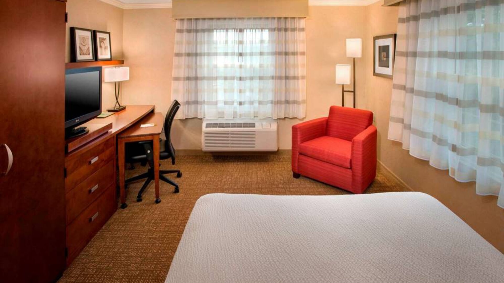 Sonesta Select Boston Danvers double bed guest room, featuring armchair, television, and desk.