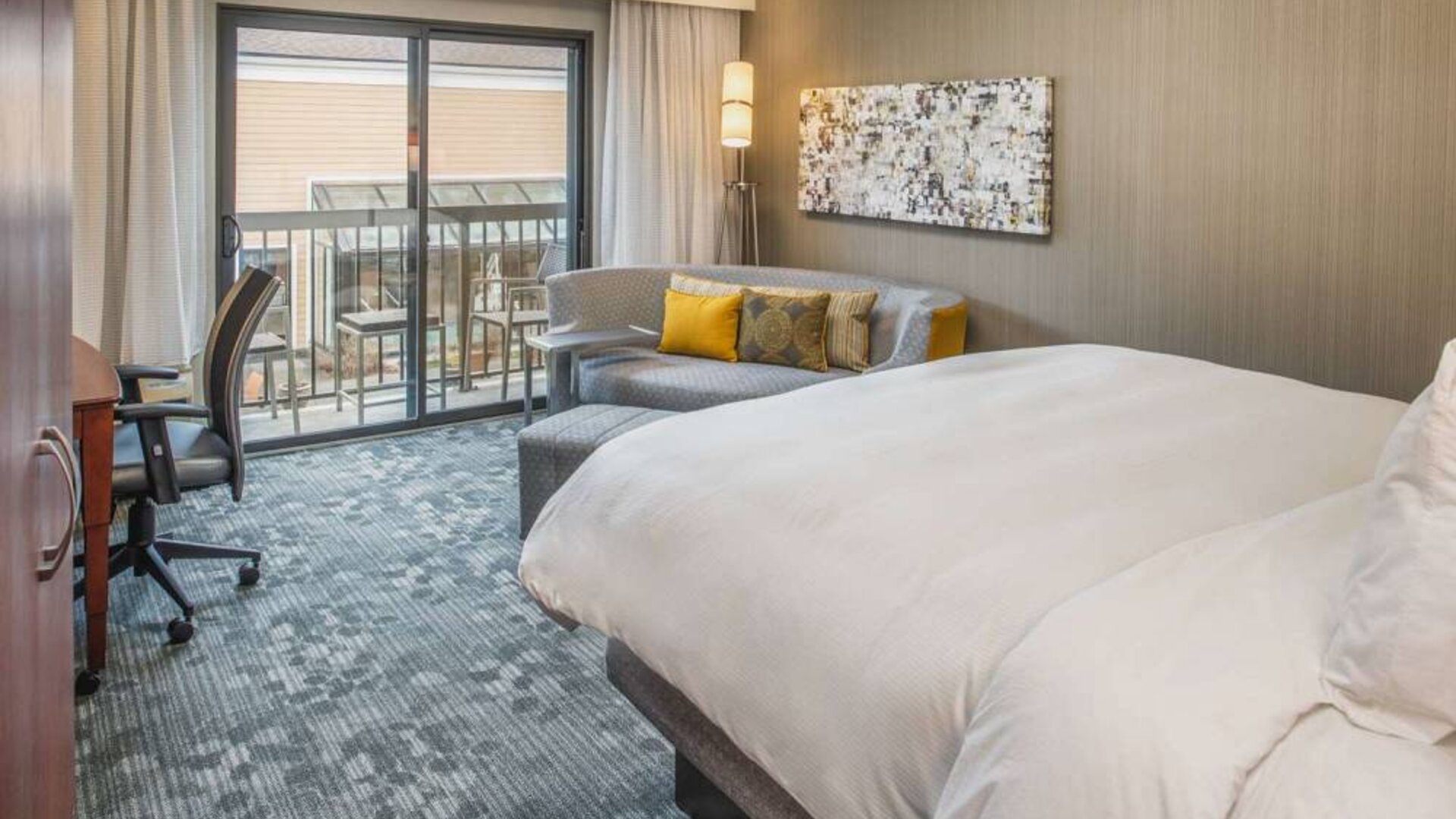 Double bed guest room in Sonesta Select Seattle Bellevue Redmond, furnished with chair, desk, and sofa.